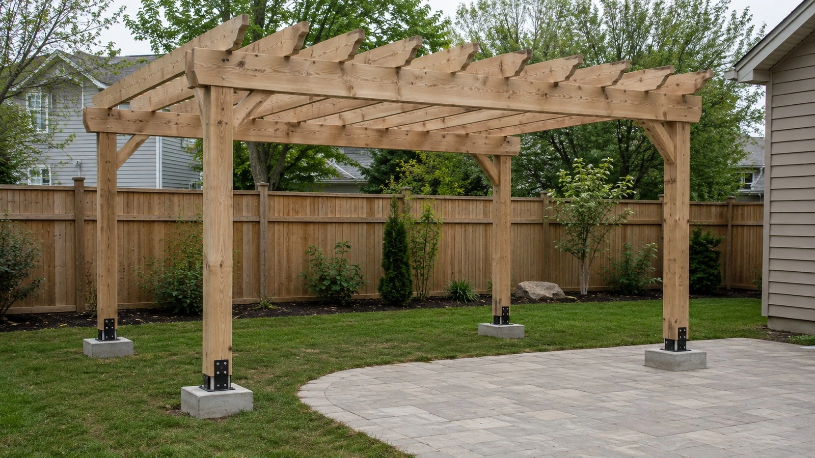 Construction-stage open pergola with posts on elevated metal bases at concrete pier locations in a North American backyard.